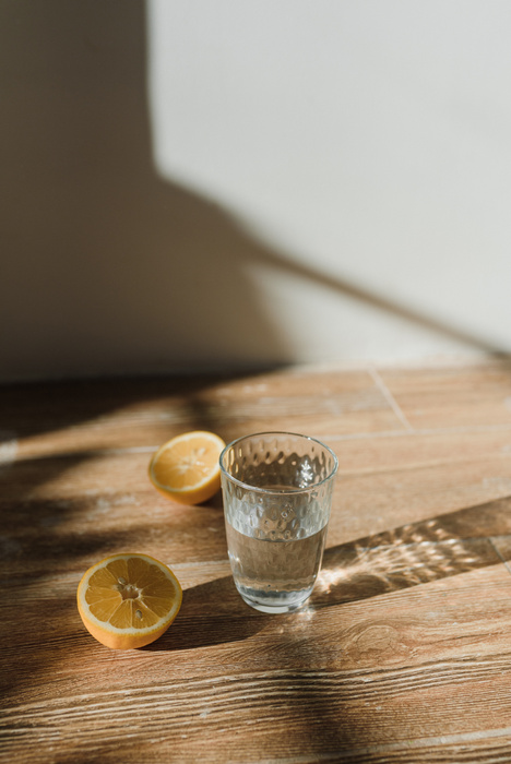 A Glass of Water Near Sliced of Lemons